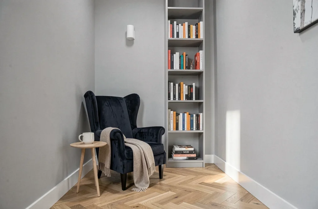 Fauteuil de lecture élégant dans un petit salon avec bibliothèque haute et déco minimaliste sans encombrement
