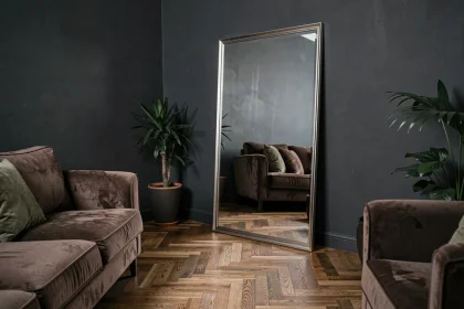 Grand miroir sur pied dans un salon aux tons sombres agrandissant visuellement l'espace intérieur