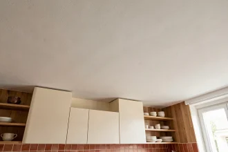 Plafond de cuisine peint en blanc mat avec texture fine, vue en contre-plongée dans un appartement moderne