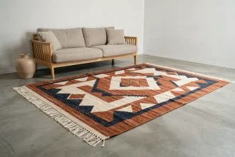 Tapis berbère à motifs géométriques terracotta et indigo sur sol en béton ciré dans un salon minimaliste scandinave